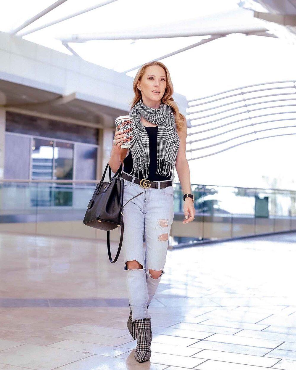 Blonde fitness blogger Eve Dawes walking airport Starbucks coffee