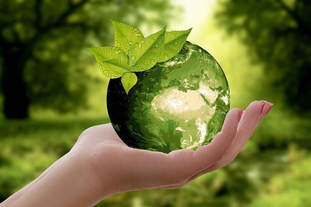 Save our planet - green living globe in hand