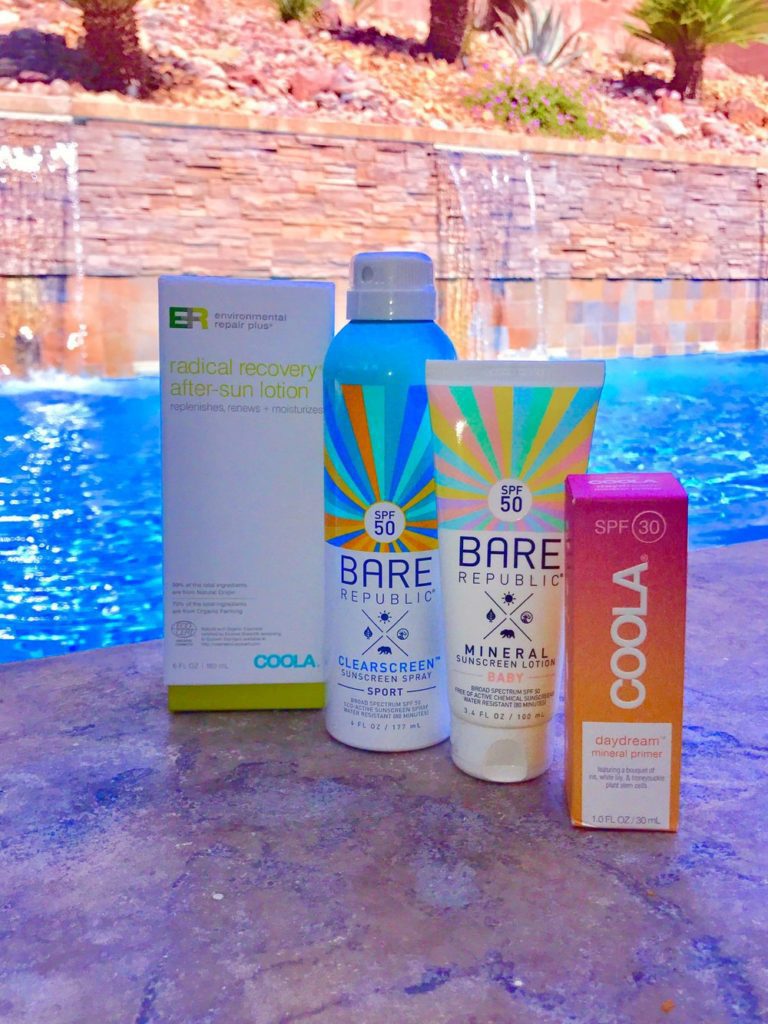 Coola sunscreen and Bare republic after sun lotion by pool waterfall