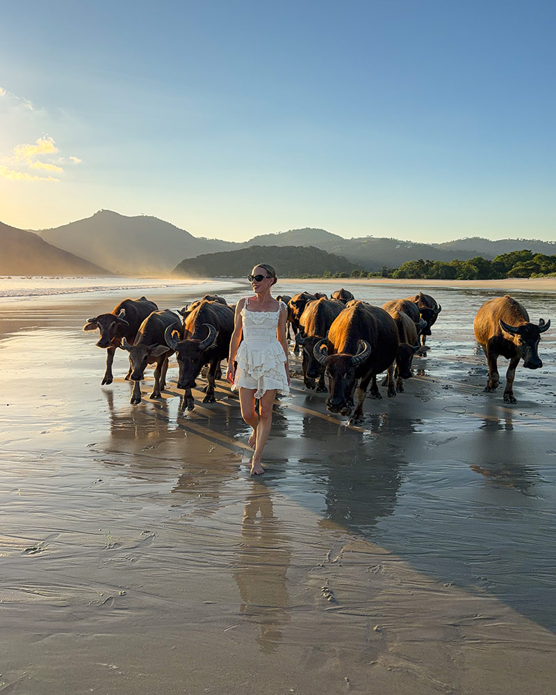 fashion trends 2026 white boho mini dress worn by Eve Dawes bare foot on beach in Lombok