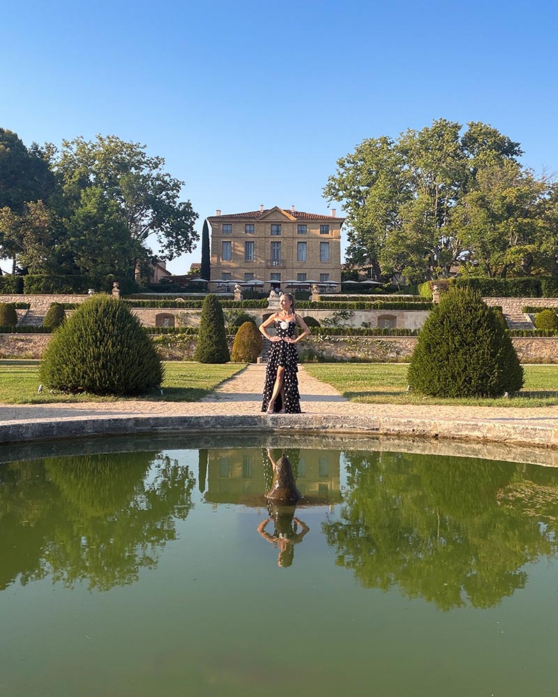 Influencer Eve Dawes in a full length black and white polka dot dress, white wedges at a chateau